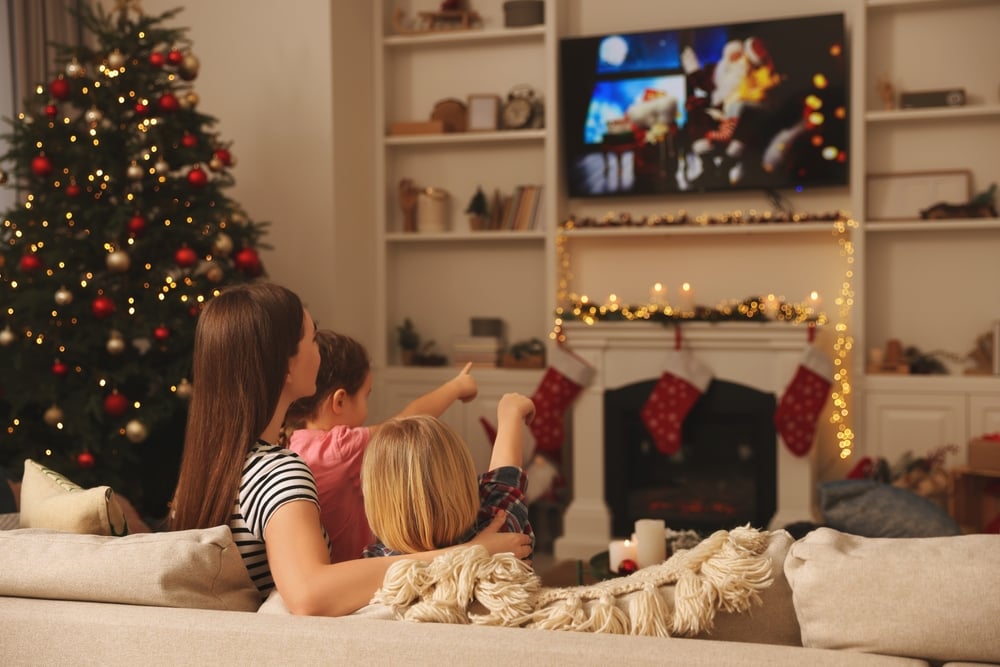 Mother,With,Her,Children,Watching,Tv,In,Cosy,Room.,Christmas